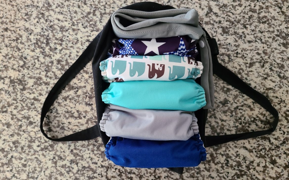 An image of a cloth bag with 5 colorful cloth diapers and a gray wet bag