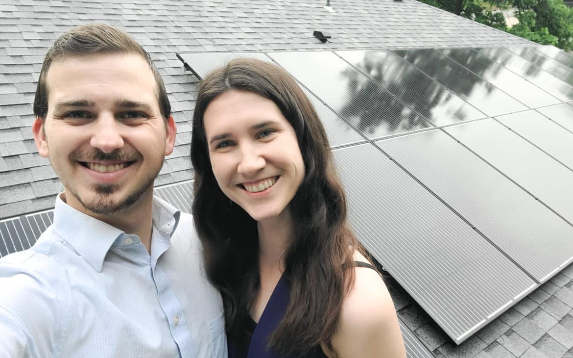 How Much Do Solar Panels Save - woman and man on roof with solar panels