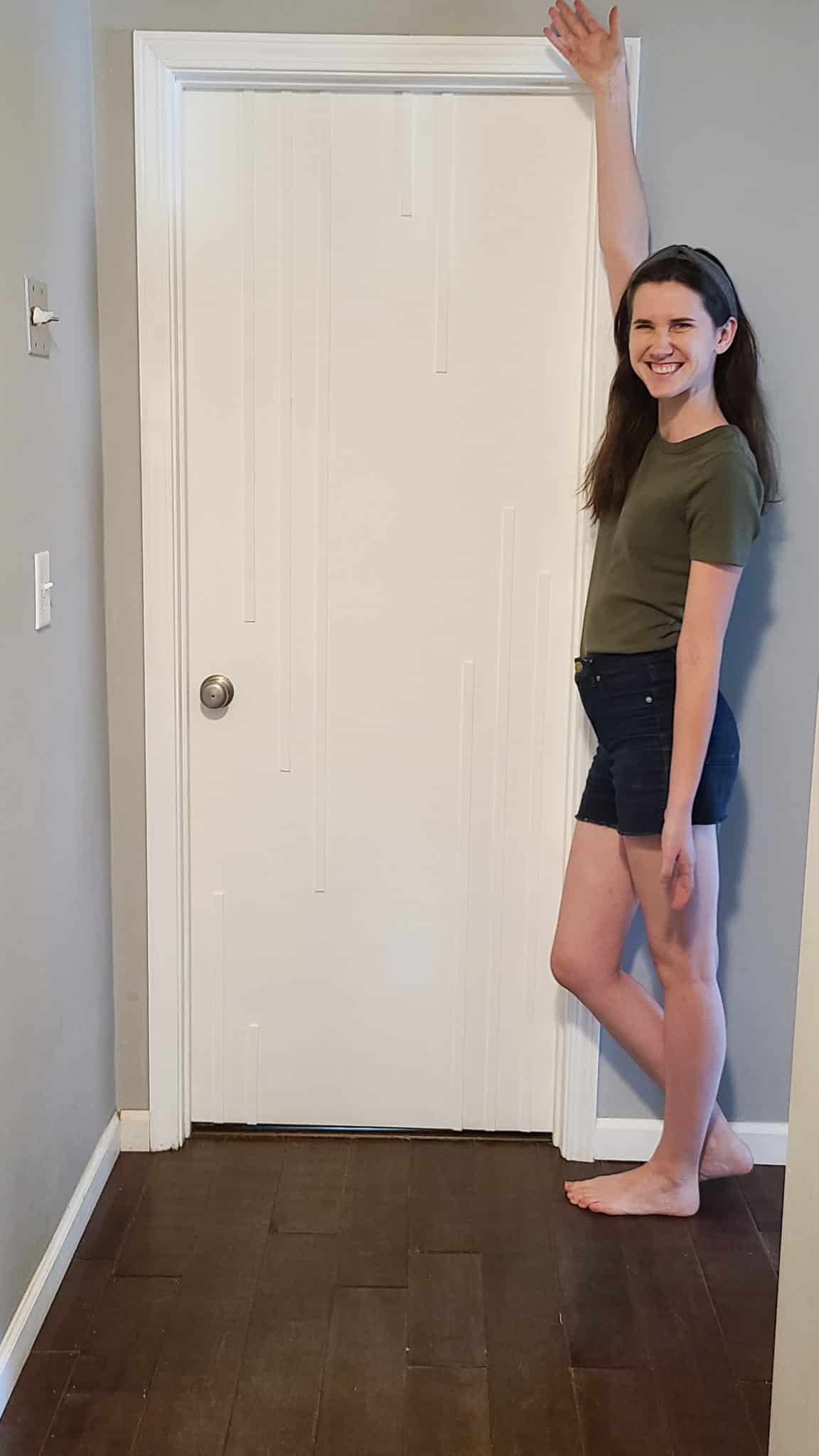 woman standing beside completed DIY interior door makeover