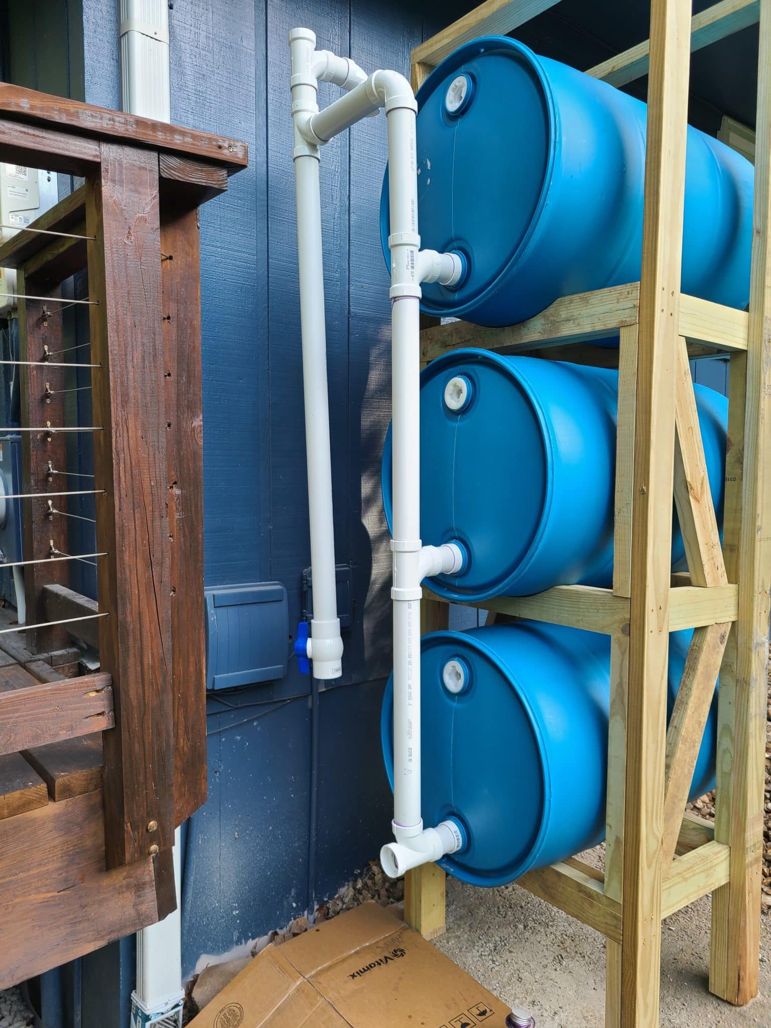 showing assemble of vertical plumbing for stacked rain barrel system