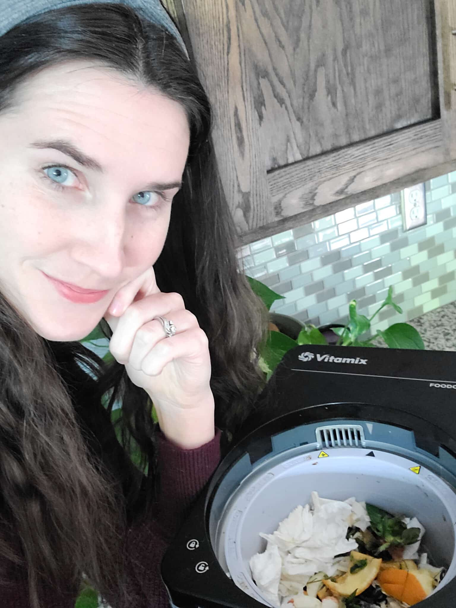 woman looking at her Vitamix Foodcycler (aka electric composter) full of food scraps