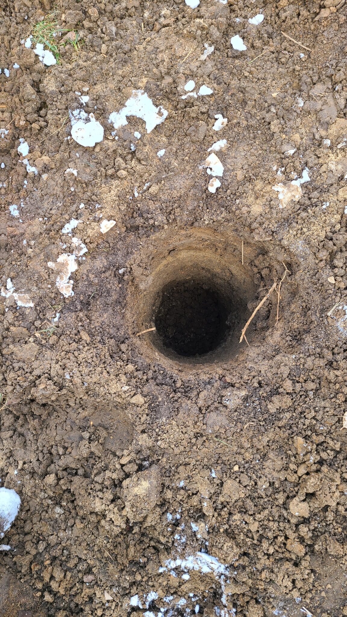 Post hole for a wood retaining wall