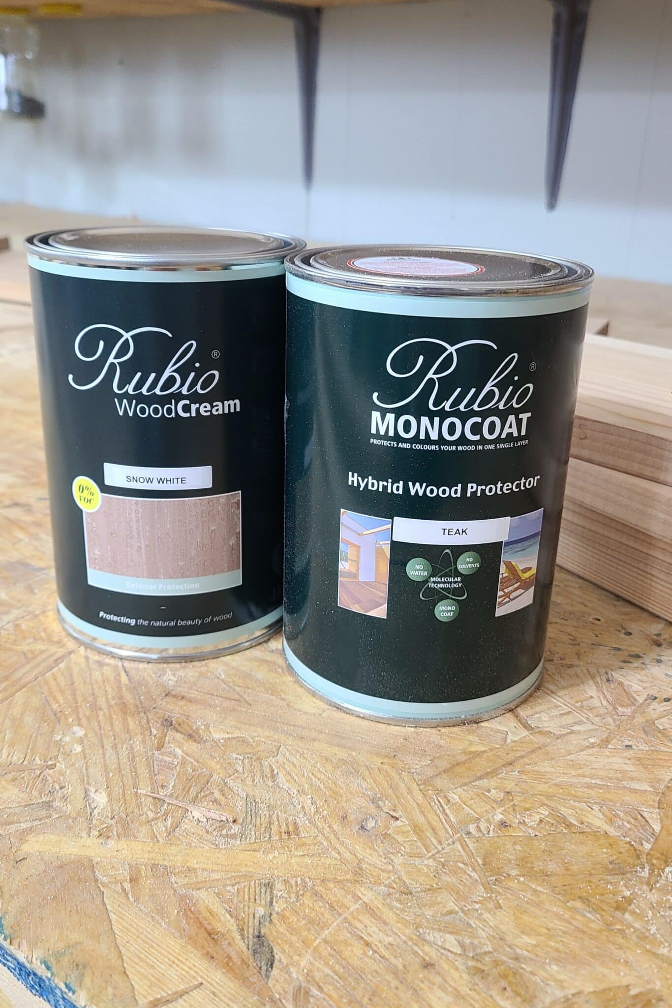 Picture of Rubio's WoodCream next to Rubio's Hybrid Wood Protector sitting on a workbench surface
